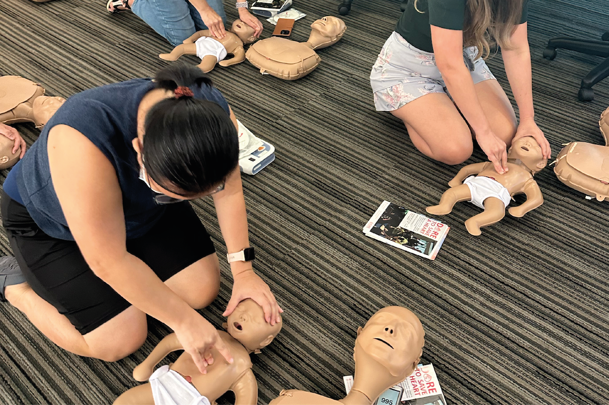 Photo of several learners practicing infant CPR on baby mannequins.